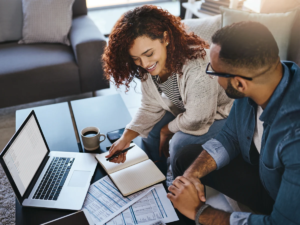 Couple reviewing paper documents and laptop