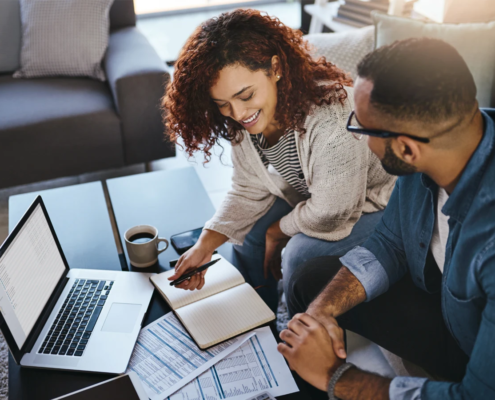 Couple reviewing paper documents and laptop